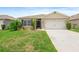 Well-maintained lawn and landscape adorn this single-story home with a two car garage in this exterior home view at 341 Alexzander Way, Winter Haven, FL 33881