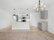 Open kitchen features a modern island, pendant lights, and eat-in dining area at 341 Alexzander Way, Winter Haven, FL 33881