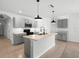 Open kitchen features modern island with sink, pendant lights, and stainless appliances at 341 Alexzander Way, Winter Haven, FL 33881