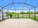 Spacious screened patio with a charming chiminea and views of the yard and the water beyond at 341 Alexzander Way, Winter Haven, FL 33881
