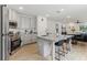 Modern kitchen features stainless steel appliances, granite countertops, a kitchen island with seating, and wood-look floors at 4122 Sagefield Dr, St Cloud, FL 34773