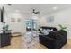 Bright living room features wood floors, a ceiling fan, neutral decor, and sliding glass doors to an outdoor space at 4122 Sagefield Dr, St Cloud, FL 34773