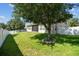 Lush green backyard with mature tree, manicured lawn and privacy fence creates a tranquil retreat for outdoor enjoyment at 4133 Foxhound Dr, Clermont, FL 34711
