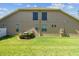 Well-maintained backyard featuring a manicured lawn, shrubbery, and architectural details offering privacy and appeal at 4133 Foxhound Dr, Clermont, FL 34711