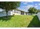 A spacious backyard offers privacy, lush green lawn, mature tree, and white vinyl fencing enhancing the property's appeal at 4133 Foxhound Dr, Clermont, FL 34711