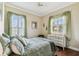 Inviting bedroom featuring bright windows with shutters, soft green accents, and hardwood floors at 4133 Foxhound Dr, Clermont, FL 34711