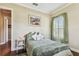 Comfortable bedroom featuring bright window and doorway, soft green accents, and hardwood floors at 4133 Foxhound Dr, Clermont, FL 34711