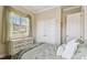 Cozy bedroom featuring bright window, soft green accents, closet doors, and hardwood floors at 4133 Foxhound Dr, Clermont, FL 34711