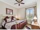 Cozy bedroom features a brass bed frame, warm lighting, and a window with sheer curtains at 4133 Foxhound Dr, Clermont, FL 34711