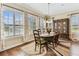 Formal dining room with large windows, wood floors, a decorative rug, and traditional furniture at 4133 Foxhound Dr, Clermont, FL 34711