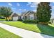 Well-maintained single-story home with stone accents, lush landscaping, and manicured lawn at 4133 Foxhound Dr, Clermont, FL 34711