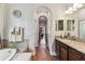 Hallway featuring bath, vanity, arched doorway, and view of bedroom at 4133 Foxhound Dr, Clermont, FL 34711