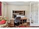 Well-lit office featuring classic wooden desk and bookshelves with a view to French doors at 4133 Foxhound Dr, Clermont, FL 34711