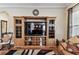 Living room features a large entertainment center, a comfortable rocking chair, and a colorful rug at 4133 Foxhound Dr, Clermont, FL 34711