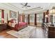 This spacious main bedroom showcases a four-poster bed, tray ceiling, and plantation shutters at 4133 Foxhound Dr, Clermont, FL 34711