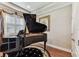 Elegant piano room featuring a grand piano, hardwood floors, and natural light from shuttered windows at 4133 Foxhound Dr, Clermont, FL 34711