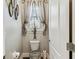 Half bath featuring toilet, window with curtains, and stylish wall decorations at 4133 Foxhound Dr, Clermont, FL 34711