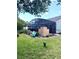 View of backyard with a screened in patio, grilling station, and landscaping at 4186 Buglers Rest Pl, Casselberry, FL 32707