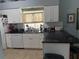 Bright kitchen with white cabinets, black countertops, and stainless steel appliances at 4186 Buglers Rest Pl, Casselberry, FL 32707