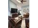 Spacious living room with tile flooring, blue walls, ceiling fan and a view of the dining room at 4186 Buglers Rest Pl, Casselberry, FL 32707
