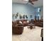 Bright living room featuring comfortable leather furniture, tile floors, and a high ceiling with a fan at 4186 Buglers Rest Pl, Casselberry, FL 32707