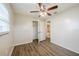 Bedroom features wood-look floors, ceiling fan with lights, and closet with an adjacent bathroom at 4200 Colony Way, Orlando, FL 32808