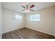 Bedroom featuring wood-look floors, two windows with blinds, and a ceiling fan with lights at 4200 Colony Way, Orlando, FL 32808