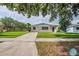 A well-maintained single-story home with lush lawn and curved driveway, framed by mature trees at 4200 Colony Way, Orlando, FL 32808