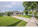 A charming single-story home boasts a well-manicured lawn, a paved driveway, and lush landscaping at 4200 Colony Way, Orlando, FL 32808