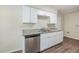 Bright kitchen with stainless steel dishwasher, gray granite countertops and white cabinets at 4200 Colony Way, Orlando, FL 32808