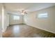 A spacious living room with wood-look floors, a ceiling fan, and two windows at 4200 Colony Way, Orlando, FL 32808