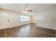 Bright living room with wood-look floors, ceiling fan, and large windows for ample natural light at 4200 Colony Way, Orlando, FL 32808