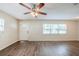 Inviting living room boasts wood-look floors, a ceiling fan, and sunlit window for a warm ambiance at 4200 Colony Way, Orlando, FL 32808