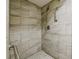 Modern shower with textured tile, handheld showerhead, and safety bars provides accessibility and style at 4200 Colony Way, Orlando, FL 32808