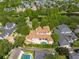Stunning aerial view of estate with beautiful landscaping, clay tile roof, backyard pool, and neighboring lake at 4400 New Broad St, Orlando, FL 32814