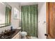 Bathroom with a black countertop and a decorative green and white shower curtain at 4400 New Broad St, Orlando, FL 32814