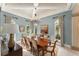 Light-filled dining room features coffered ceilings, chandelier, and multiple windows offering lush views at 4400 New Broad St, Orlando, FL 32814