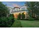 A stunning Mediterranean-style estate featuring lush landscaping, a tile roof, and an arched entryway at 4400 New Broad St, Orlando, FL 32814