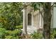Covered front porch with stone columns, decorative lanterns, and a view of lush greenery at 4400 New Broad St, Orlando, FL 32814