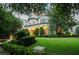Beautiful estate featuring a manicured front lawn, hedges, mature trees, architectural details, and arched entryways at 4400 New Broad St, Orlando, FL 32814