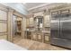 Open-concept kitchen flows to living area and features stone floors and stainless appliances at 4400 New Broad St, Orlando, FL 32814