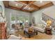 Elegant living room featuring a coffered ceiling, iron staircase, and access to an outdoor patio at 4400 New Broad St, Orlando, FL 32814