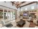 Open-concept living room with high ceilings, wooden beams, custom entertainment center, and access to outdoor space at 4400 New Broad St, Orlando, FL 32814