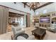 Outdoor living area with coffered ceilings, a fireplace, and a dining table next to a luxurious pool at 4400 New Broad St, Orlando, FL 32814