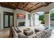 Inviting outdoor living area featuring a stone fireplace with TV, coffered ceiling, and comfortable seating at 4400 New Broad St, Orlando, FL 32814