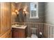 Stylish powder room with decorative wallpaper, sconces, vanity and sink, and a framed mirror at 4400 New Broad St, Orlando, FL 32814