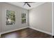 Well-lit bedroom with laminate wood flooring, two windows, and neutral paint at 461 Black Knight Way, Longwood, FL 32779