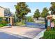 Gated community entrance with brick pillars, iron gate, and lush greenery at 461 Black Knight Way, Longwood, FL 32779