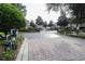 Community entrance featuring a gate with brick-paved road and lush greenery at 461 Black Knight Way, Longwood, FL 32779
