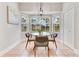 Sun-drenched breakfast nook with a glass table and chairs next to three windows at 4993 Hook Hollow Cir, Orlando, FL 32837